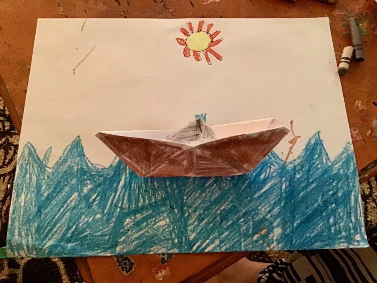 Origami boat colored brown on a drawing of water with a yellow sun