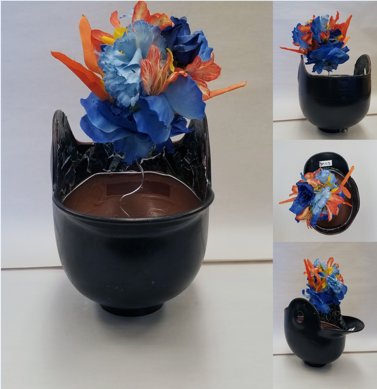 Black baseball helmet flipped upside down with blue and orange flowers emerging on a spring.