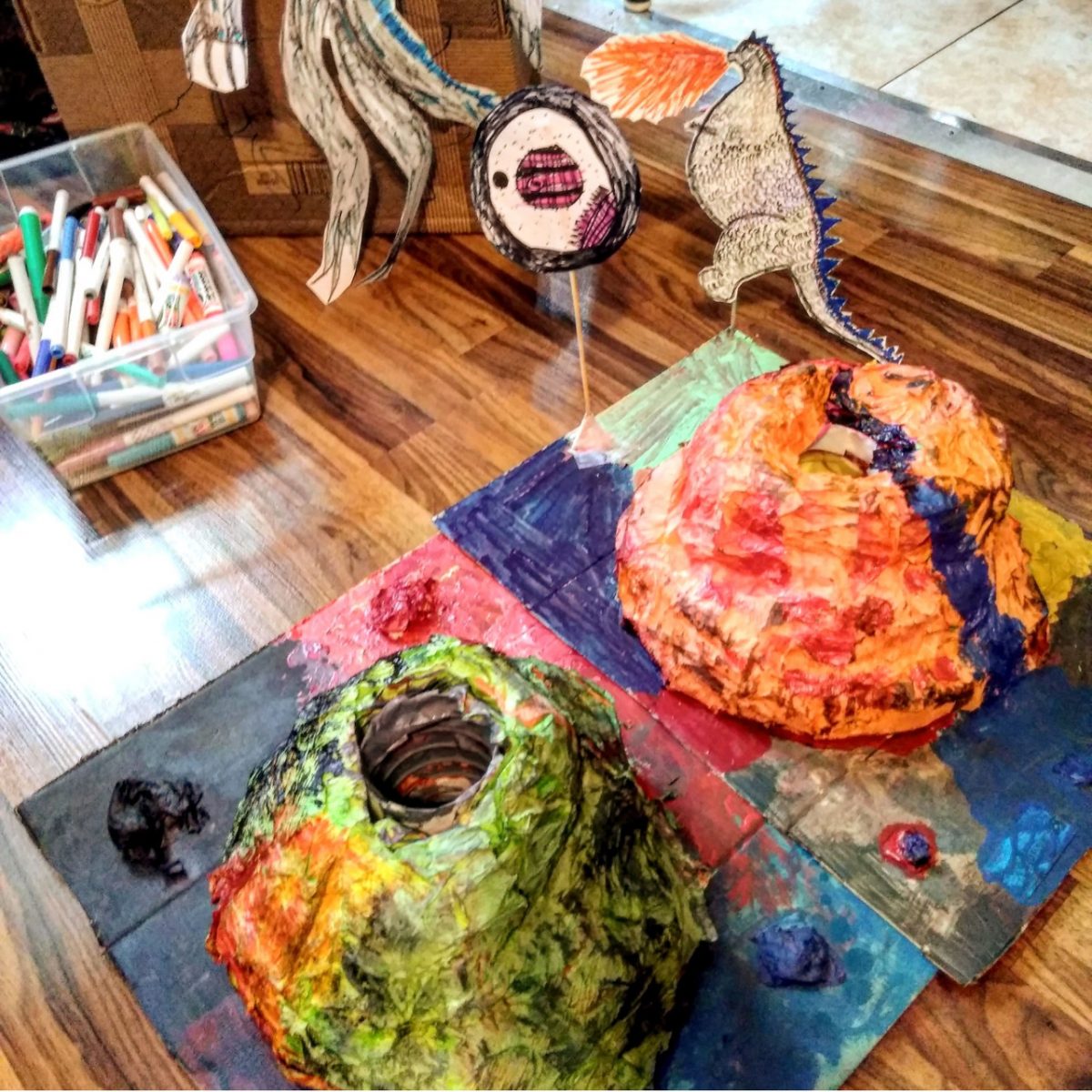 Two newspaper mache volcanos painted rainbow