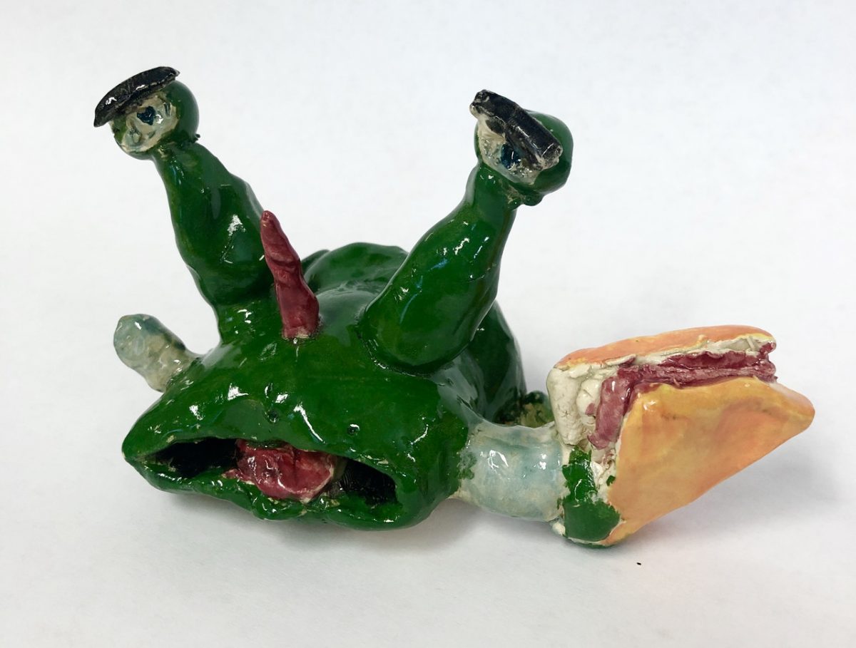 Green alien with a horn holding a taco