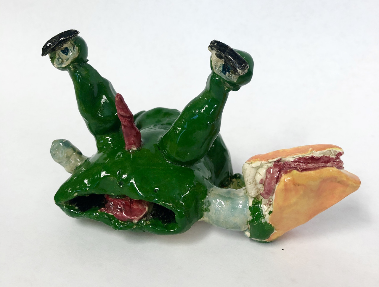 Green alien with a horn holding a taco