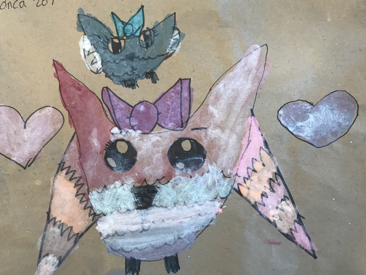 Two pastel owls and a heart on butcher paper.