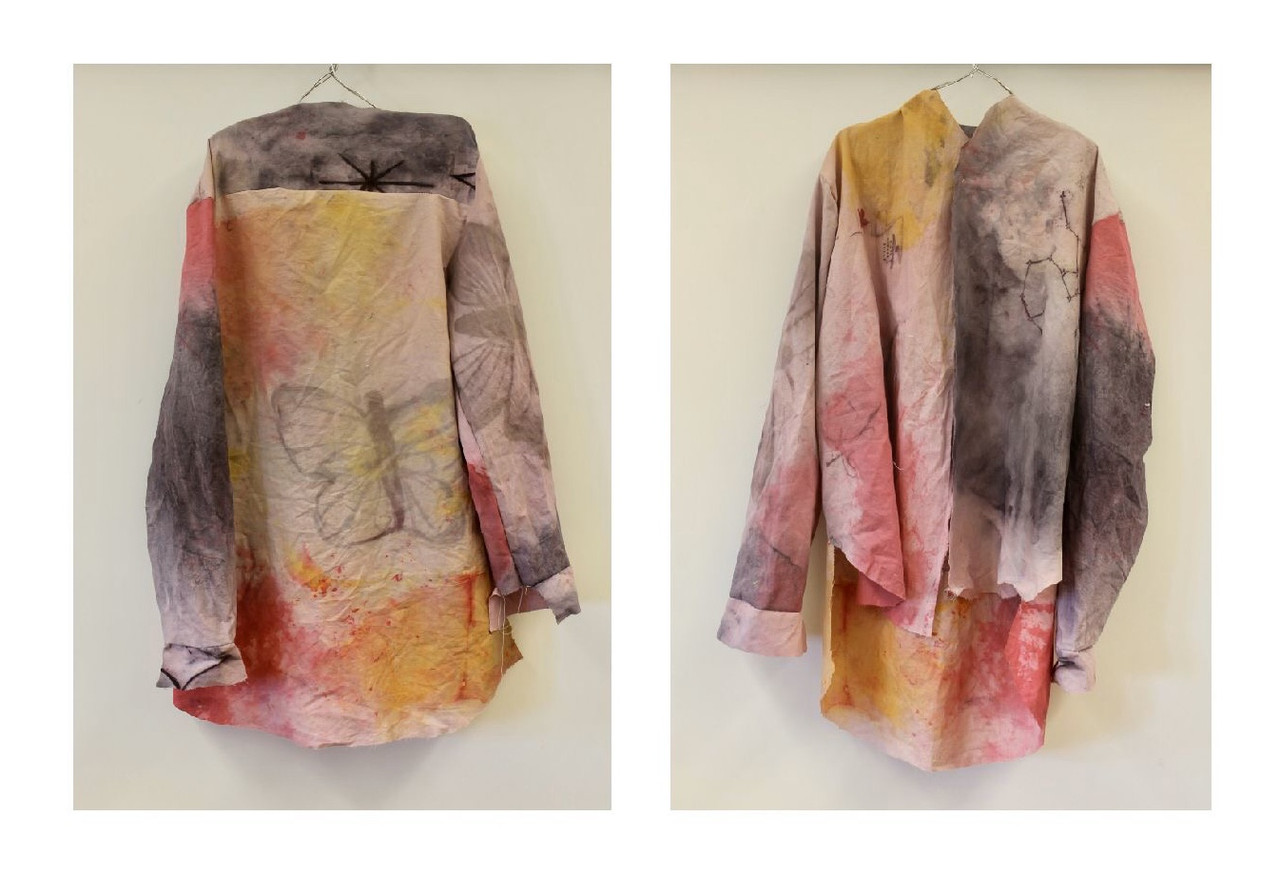 Light colored button up shirt dyed with red, black, and yellow dye with a butterly outline on the back