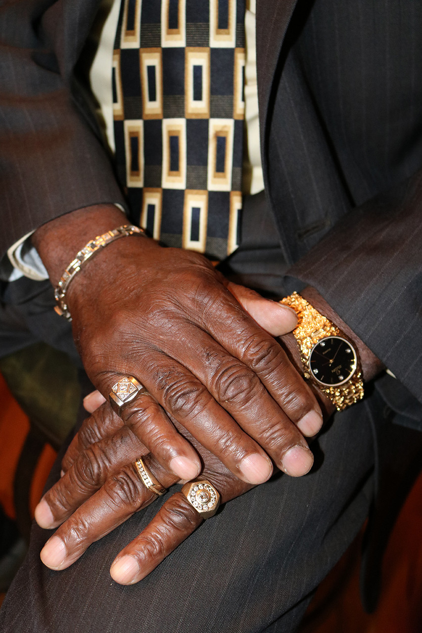 Photo of pair of hands laid on-top one another with rings, bracelet, and watch in view