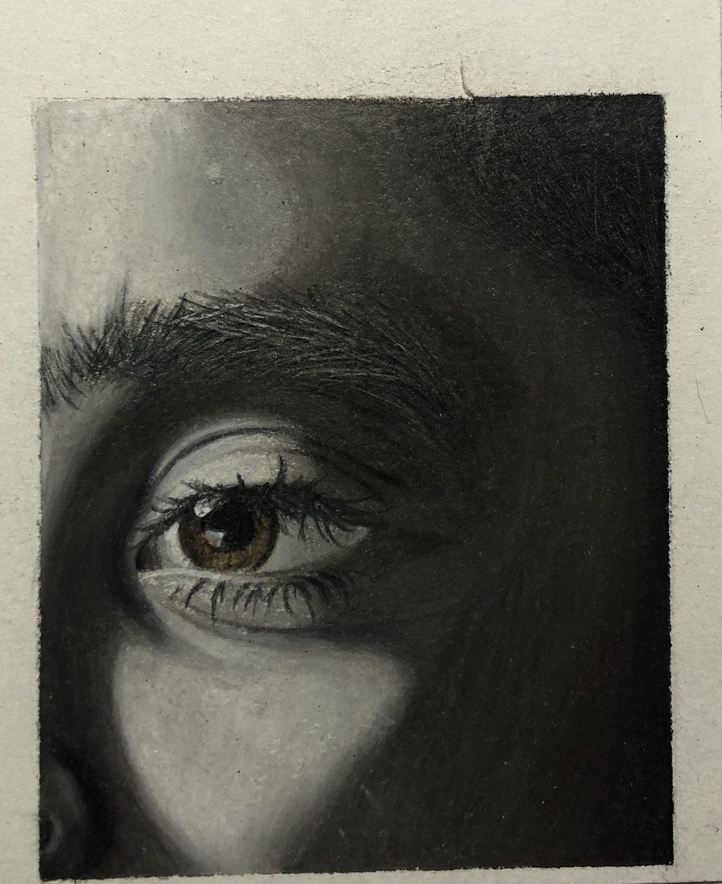 Dark pencil drawing of a face, focused on the eye