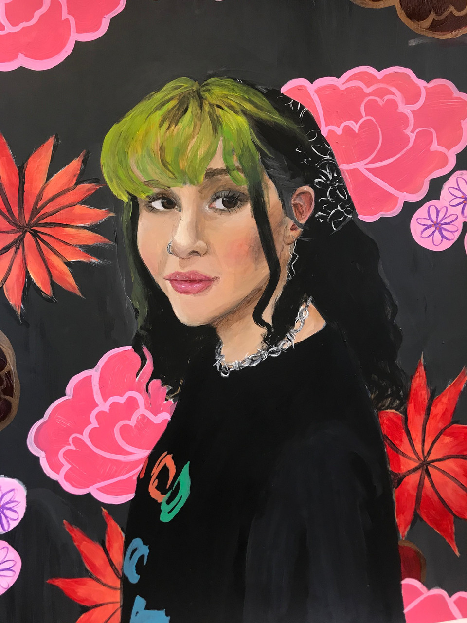 Portrait of girl with black hair and green bangs on a black blackground with large pink flowers