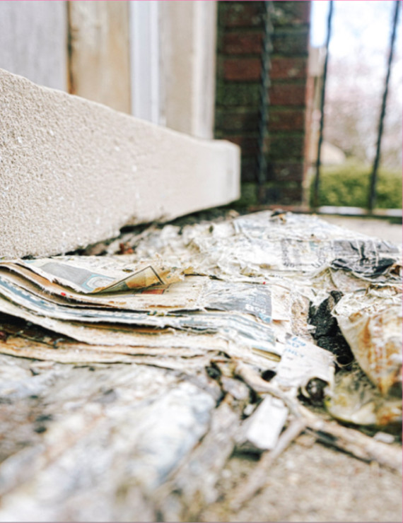 Photograph of wet paper on a stoop.