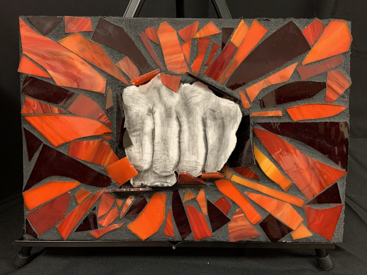 black and white drawing of a punching fist surrounded by mosaic of broken, orange fragments