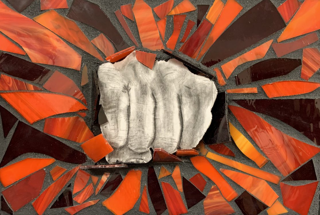 black and white drawing of a punching fist surrounded by mosaic of broken, orange fragments