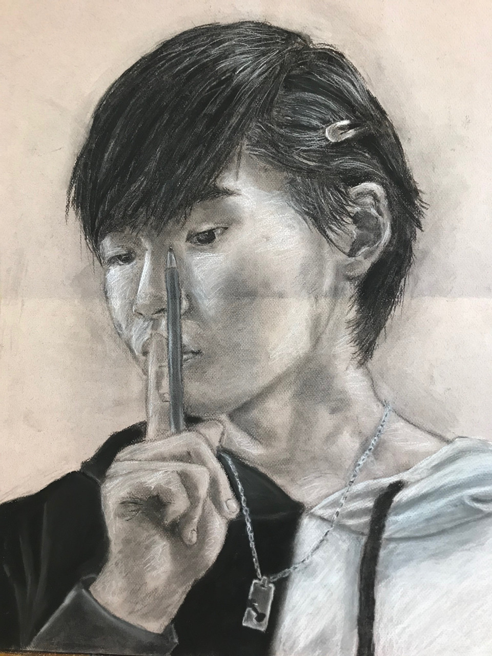 Black and white drawing of person with dark, short hair holding a pencil and finger over their mouth