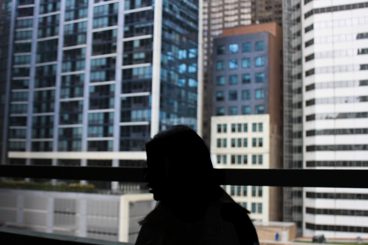 A photograph of the silhouette of a person and buildings in the background.