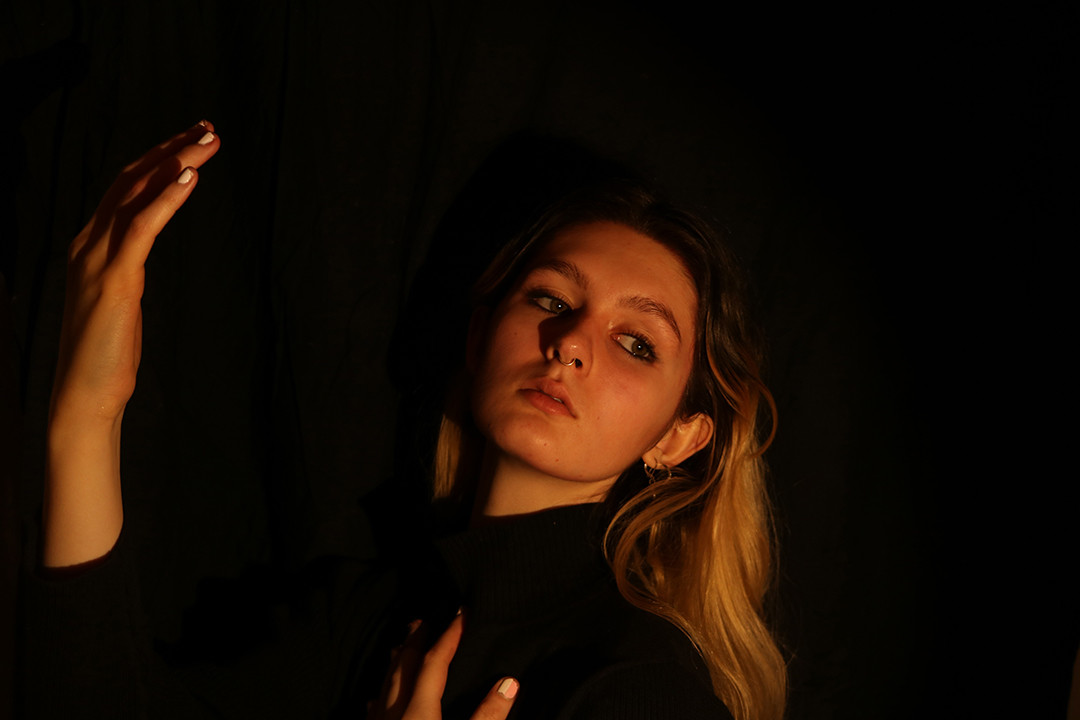 Photo of young woman posing dramatically in low lighting