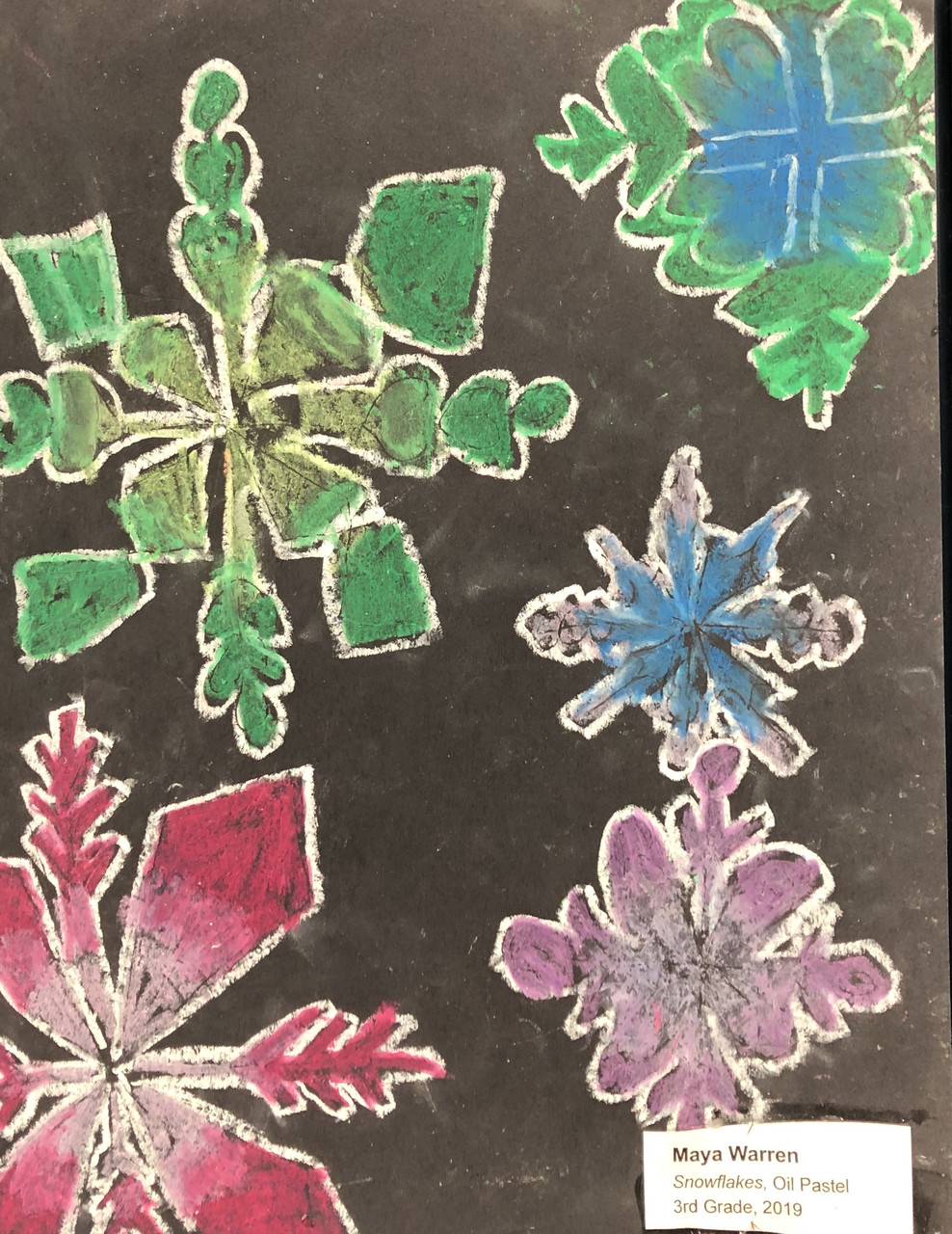 Multicolored snowflakes outlined in white on a black background