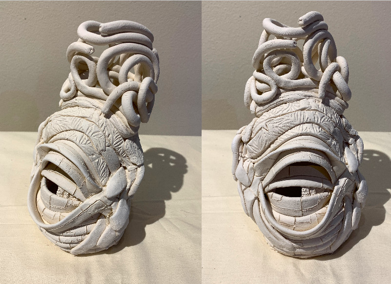 Abstract sculpture of white lines in a shoe-like form.