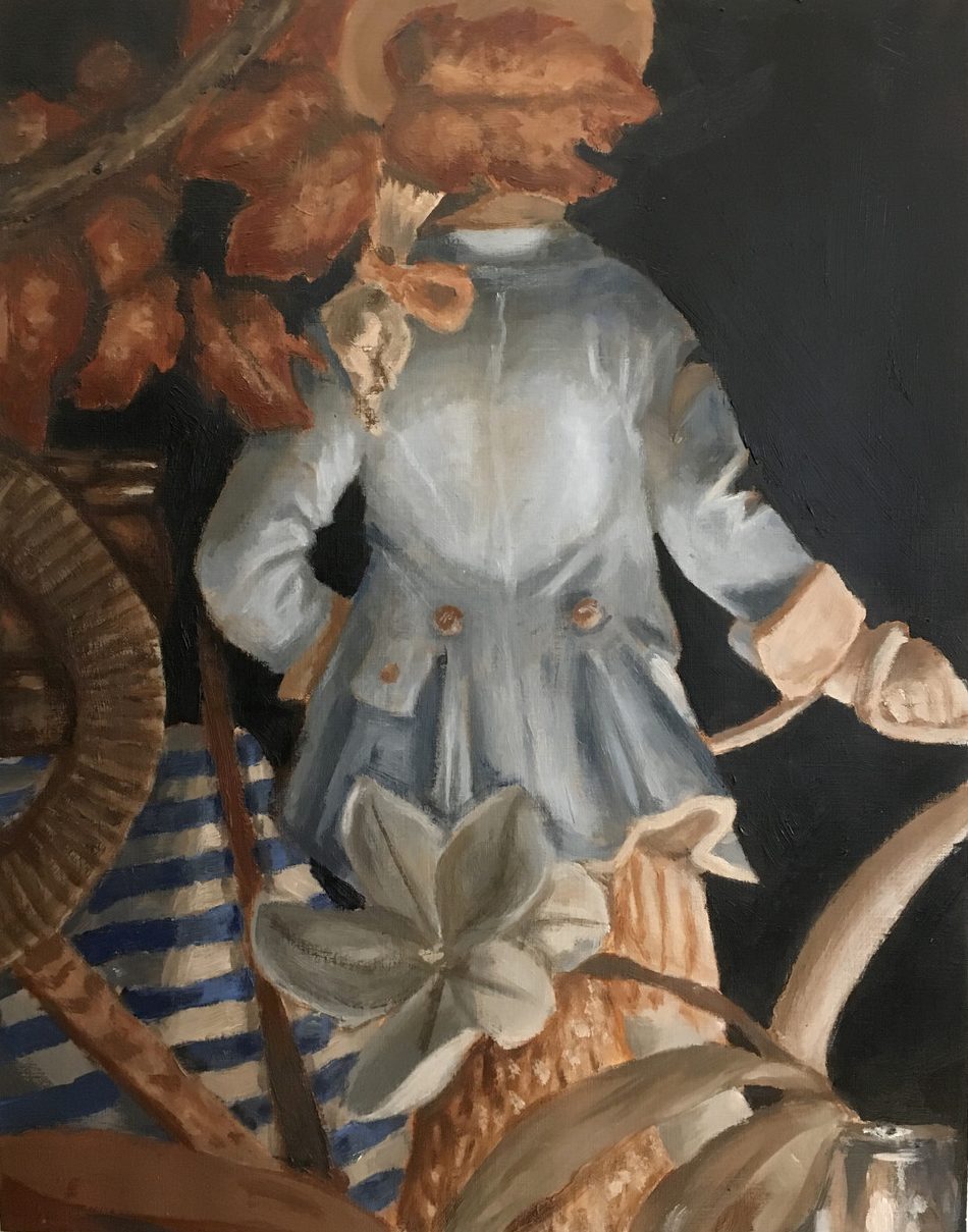 Flower in foreground with a subject dressed in a blue coat turned away from viewer