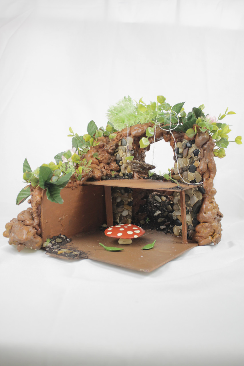 Rocks and greenery surround a setting of a small table and mushroom