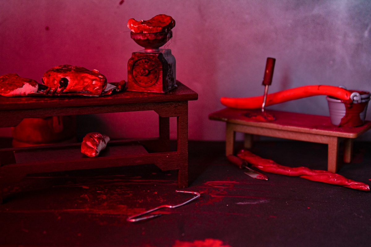 A table with a scale weighing meat, and other produce on a table