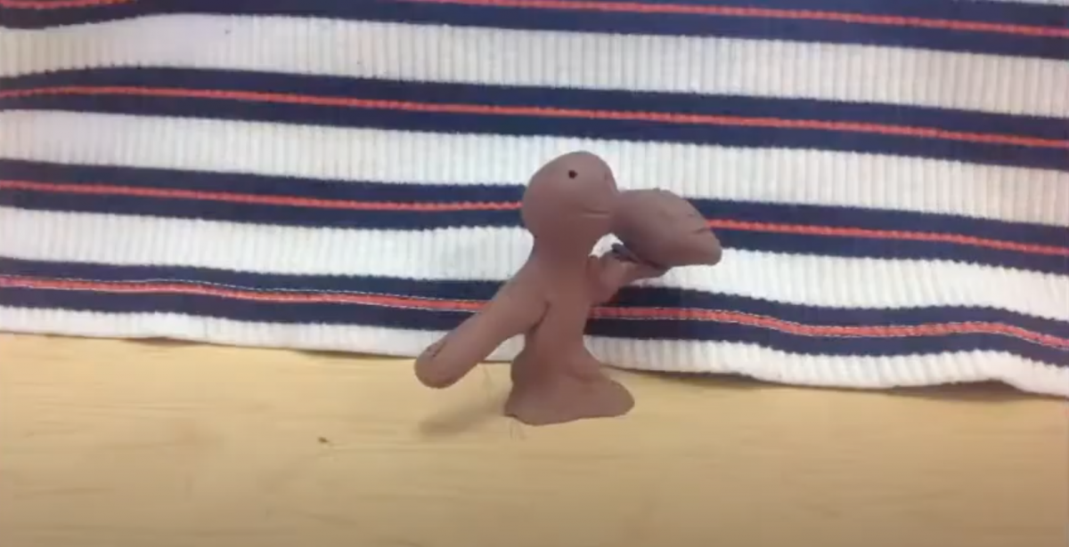 Claymation sculpture in front of a striped background