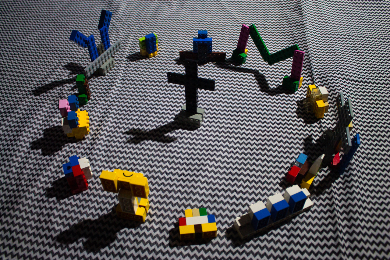 Photo of circle of lego figures around toy cross