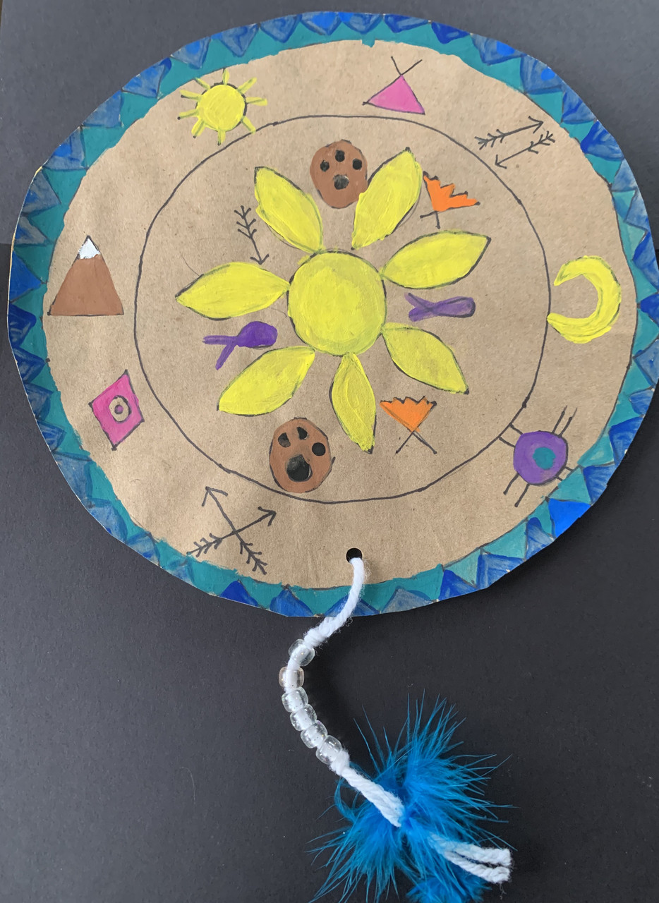 A shield with nature-inspired designs and a feather detail