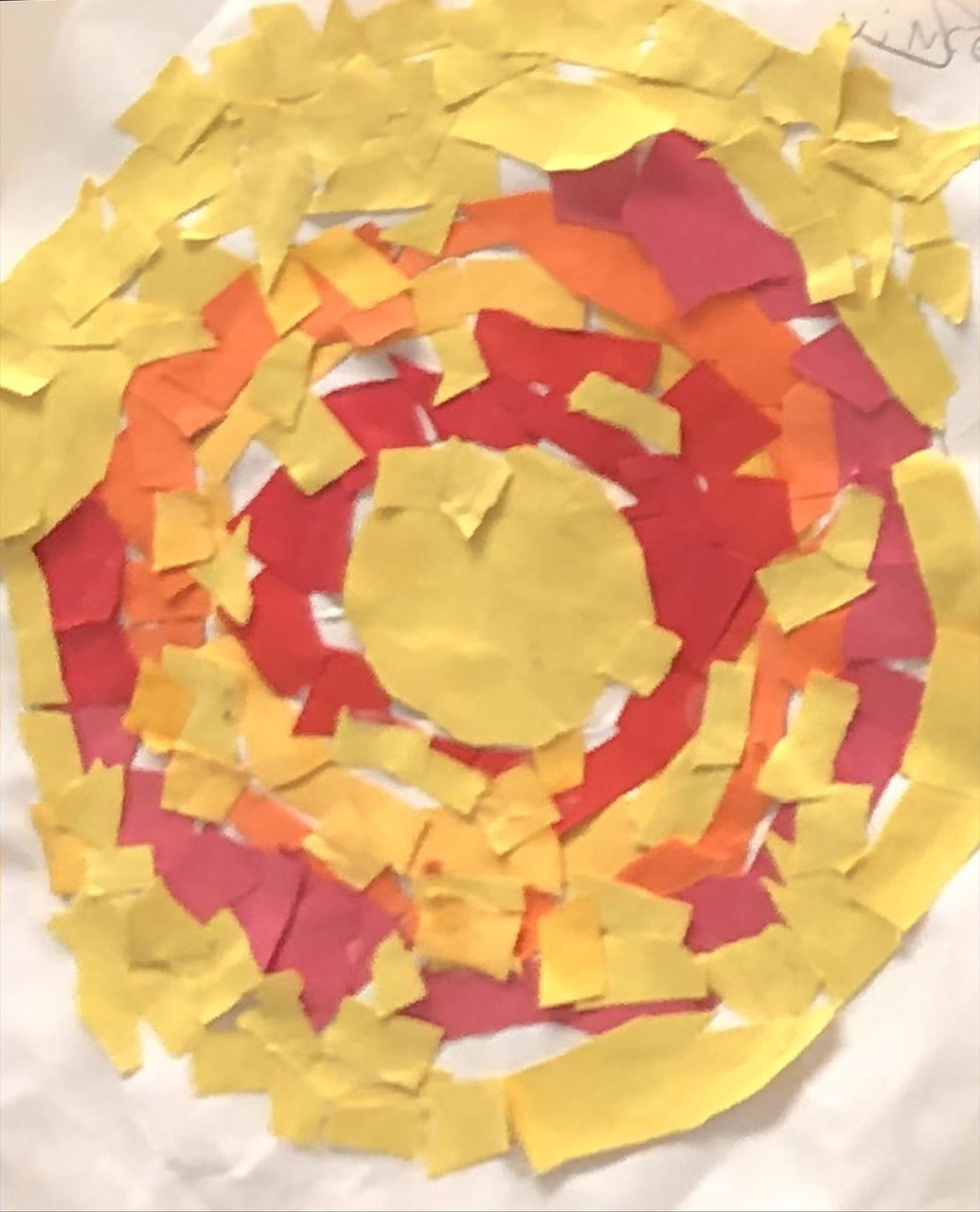 Concentric circles made of cut paper of yell, red, and orange