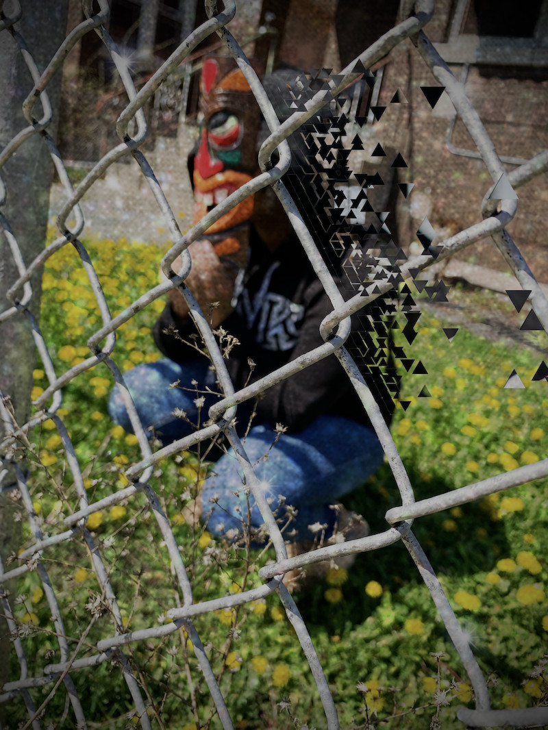 Photo of a masked person behind a fence