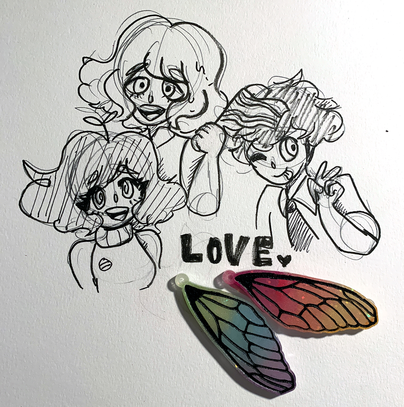 photograph of a drawing of 3 people and 2 plastic wings