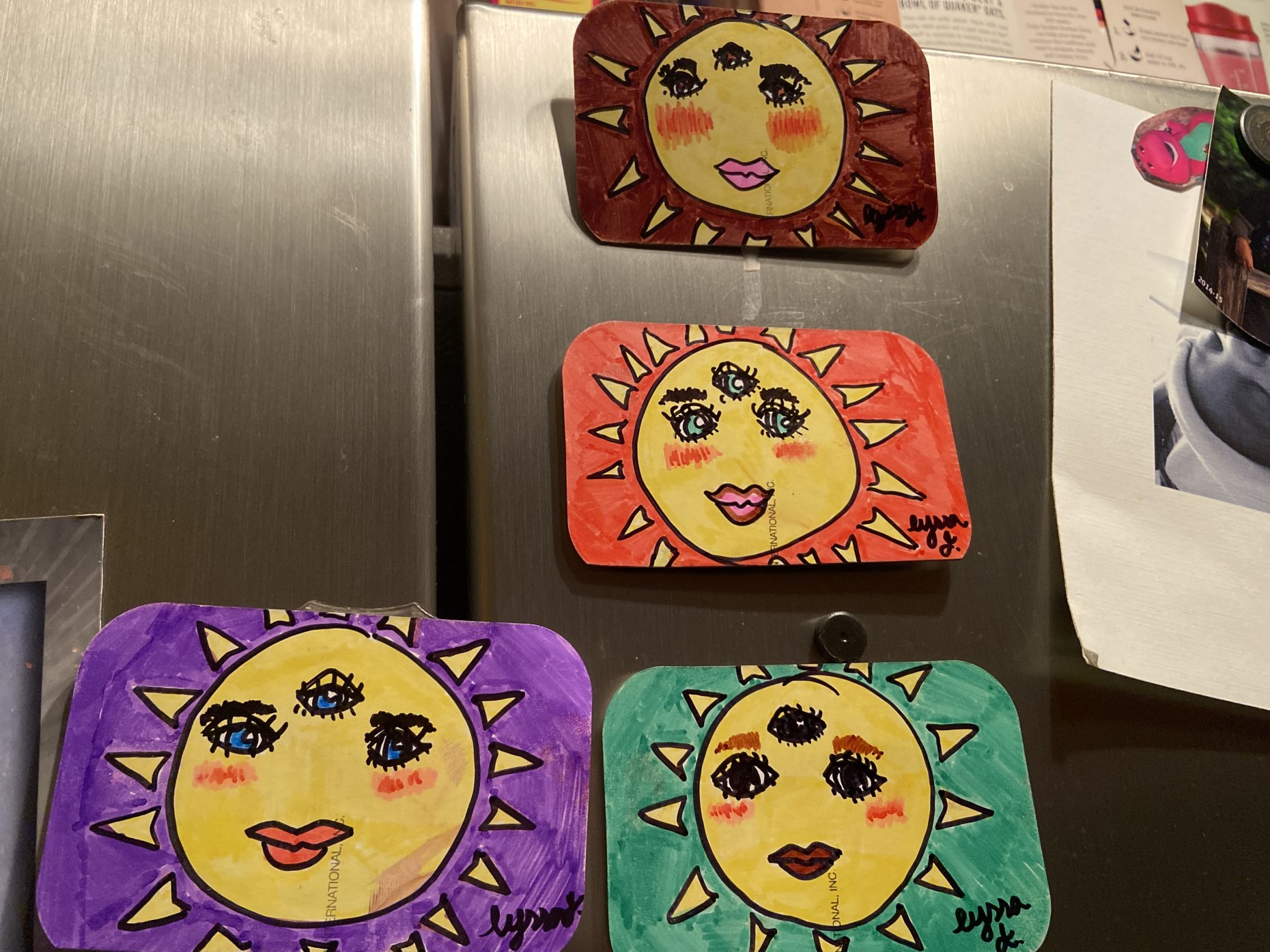 Series of 4 drawings on magnets, each with three eyes and on four different colored backgrounds.