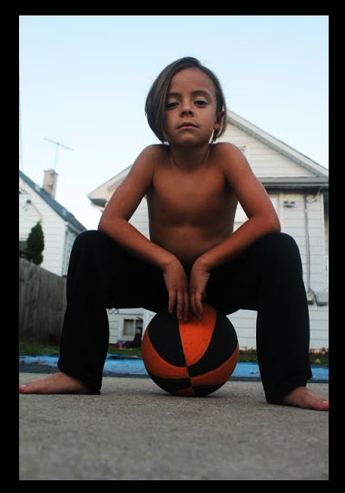Photo of a person sitting on a basketball.