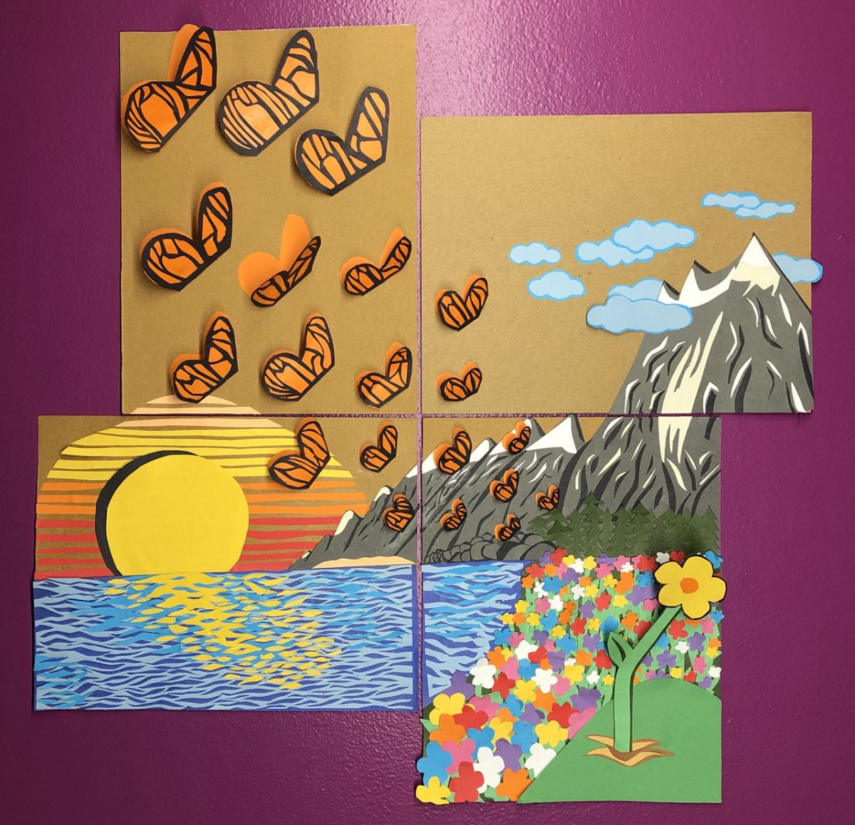 Landscape scene of sunset, mountains, flowers and butterflies made with cut out shapes from construction paper and cardboard.