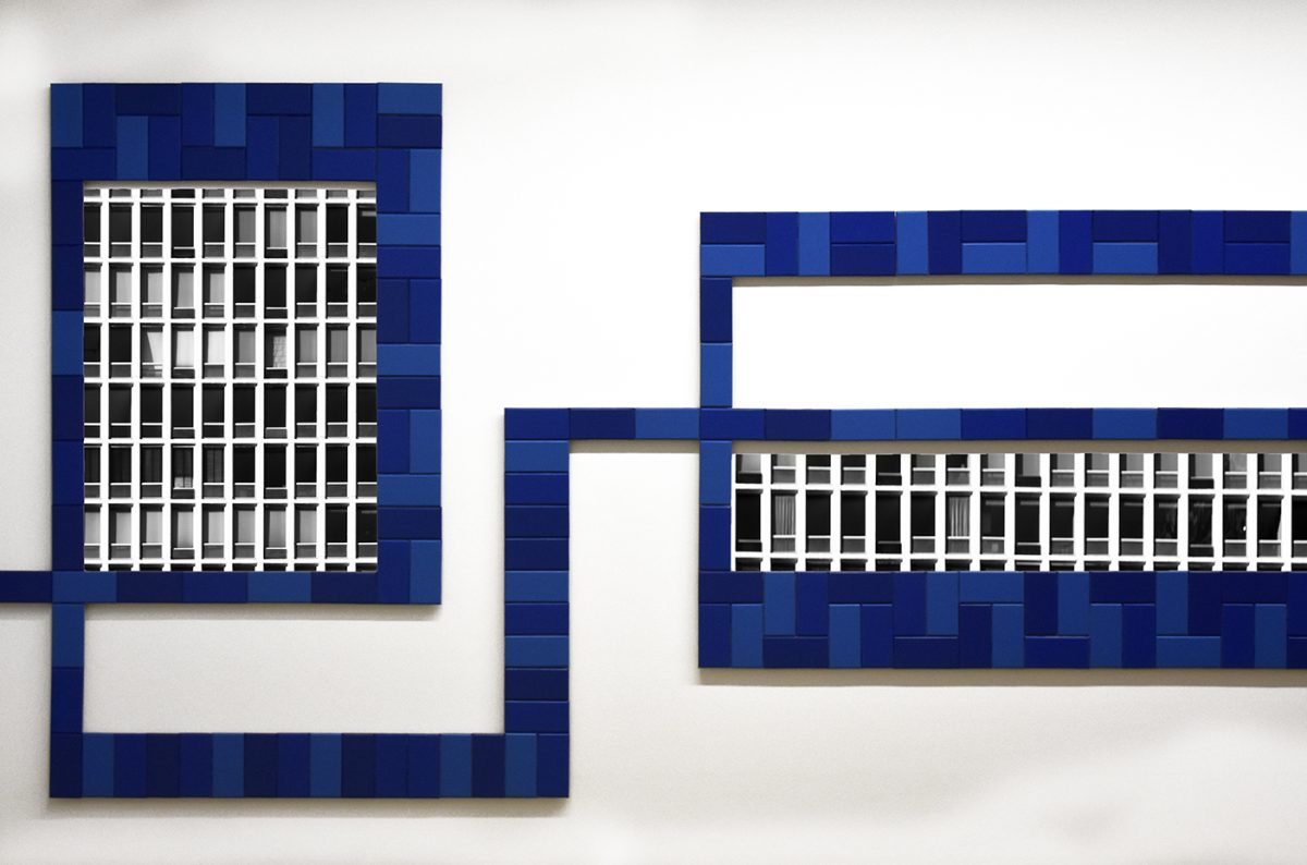 Two photos of grayscale sides of buildings, framed with blue tiles in an abstract pattern linked between the two.