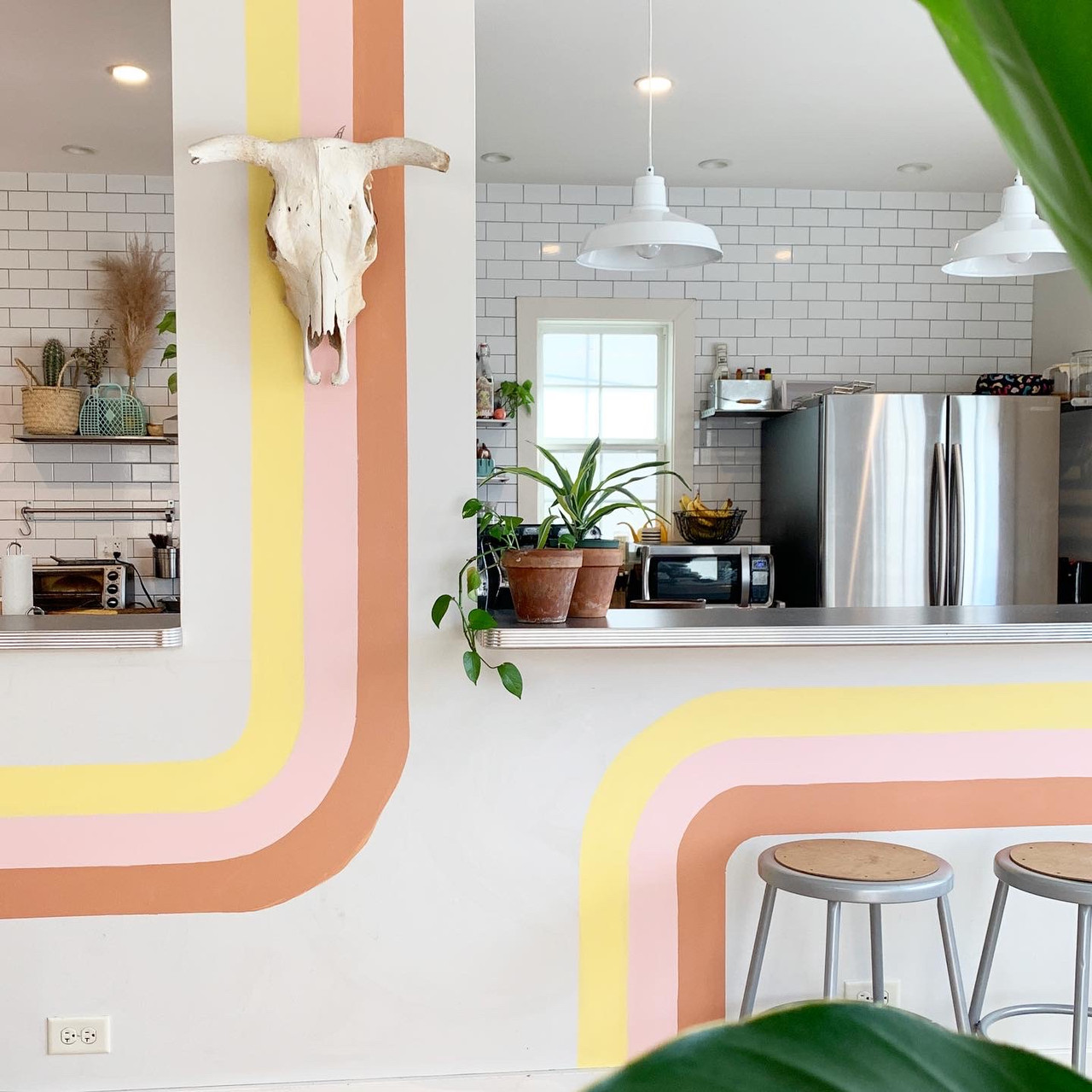 Kitchen counter with yellow, salmon, and pink rainbow. Cow skull hangs on the wall.