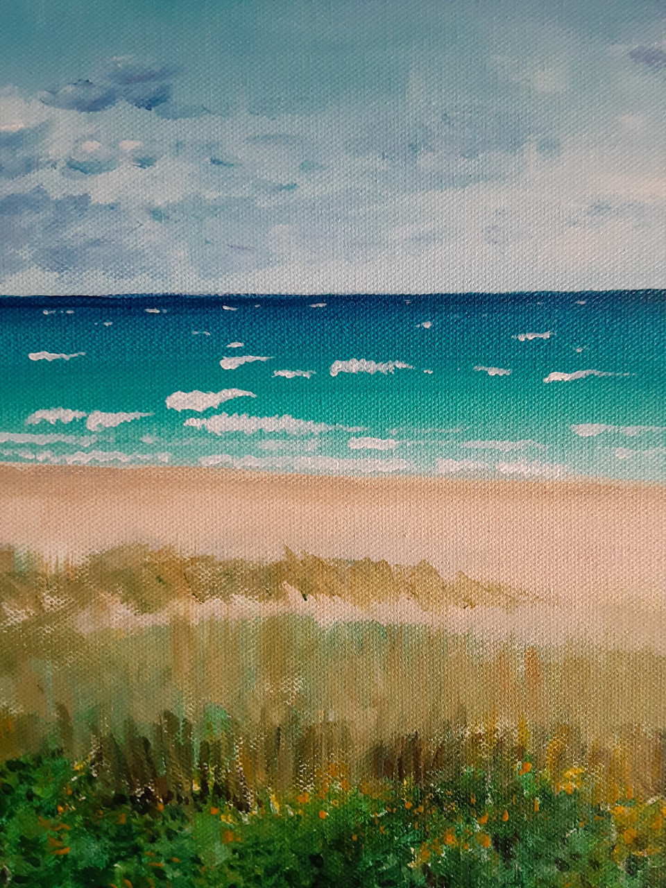 Painting of beach with green grass in foreground, sand, water, and a blue sky with some light clouds.