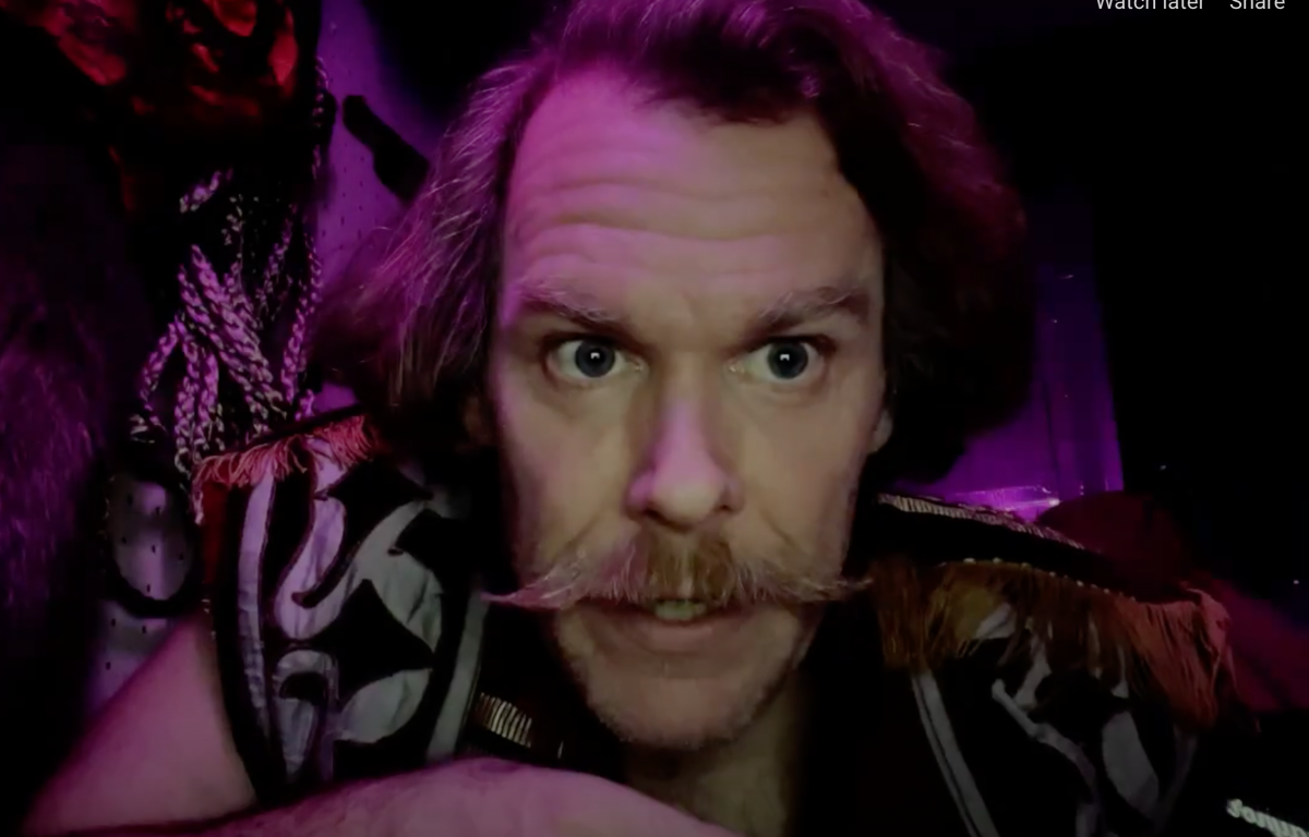 Man with large mustache in purple light
