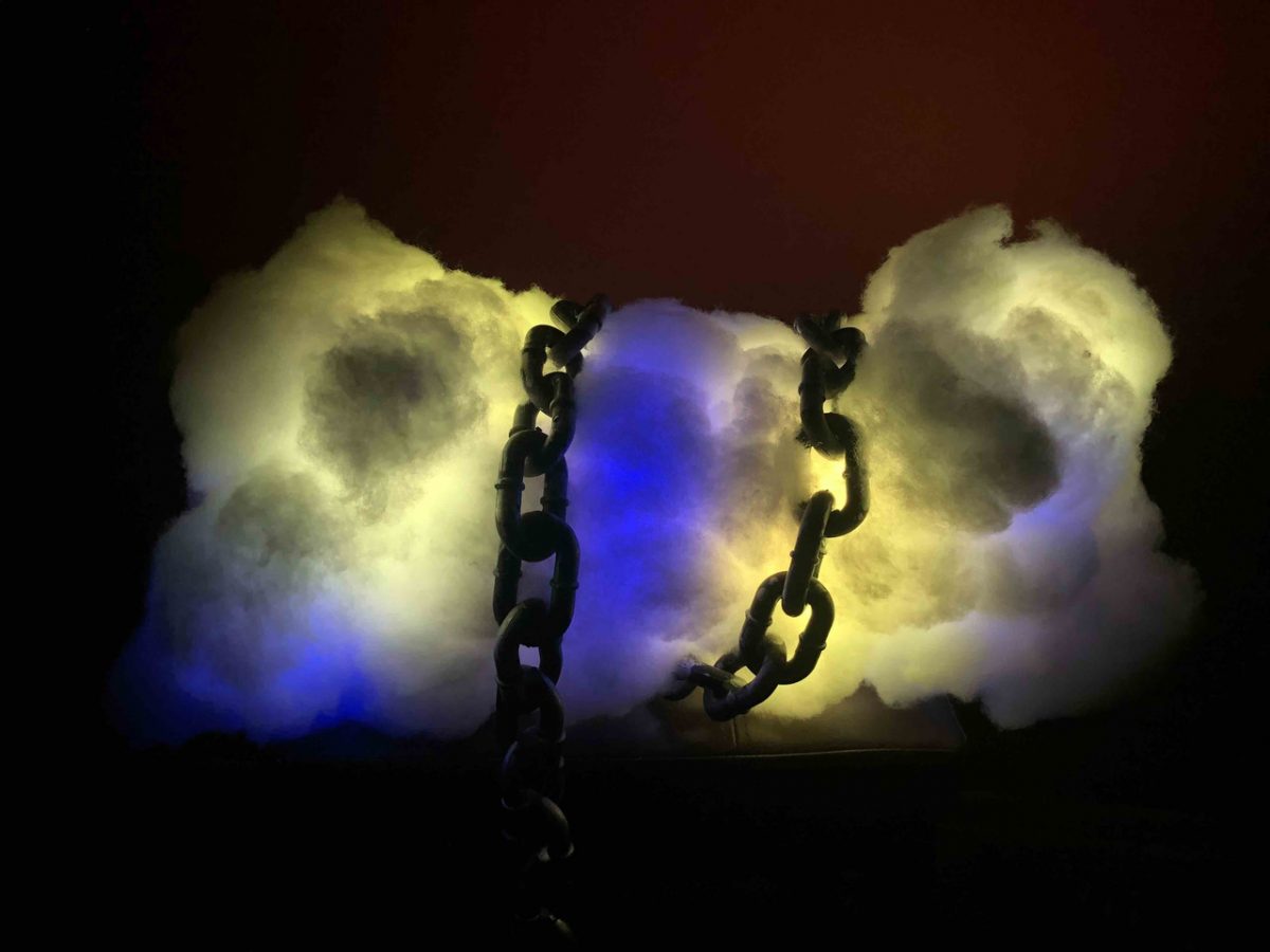 Sculpture of clouds with lights in the middle and chains wrapped around