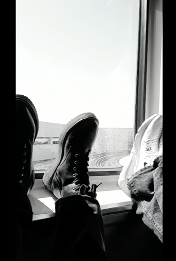 feet in the back window of an el car