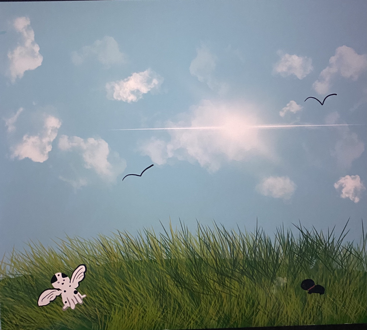 A drawing of a bright blue sky with some clouds, green grass, and a small animal on the ground