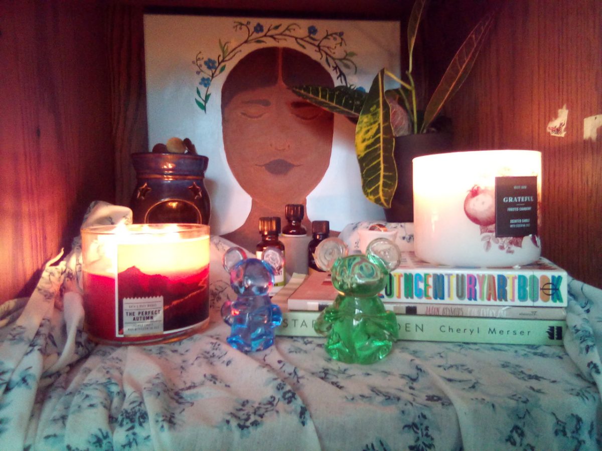 Installtion with a candle, a picture of a girl and some figurines