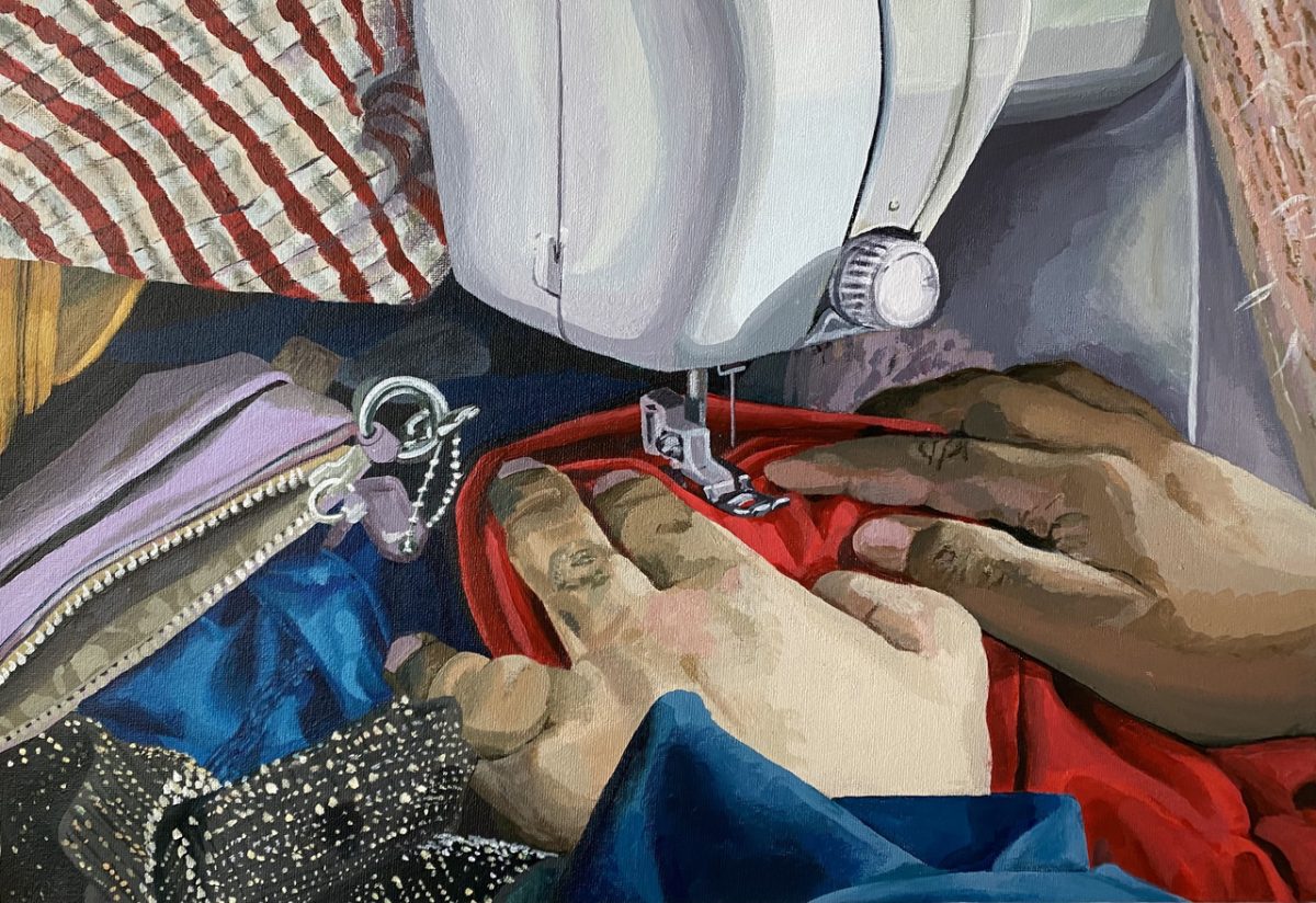 hands surrounded by fabrics using a sewing machine