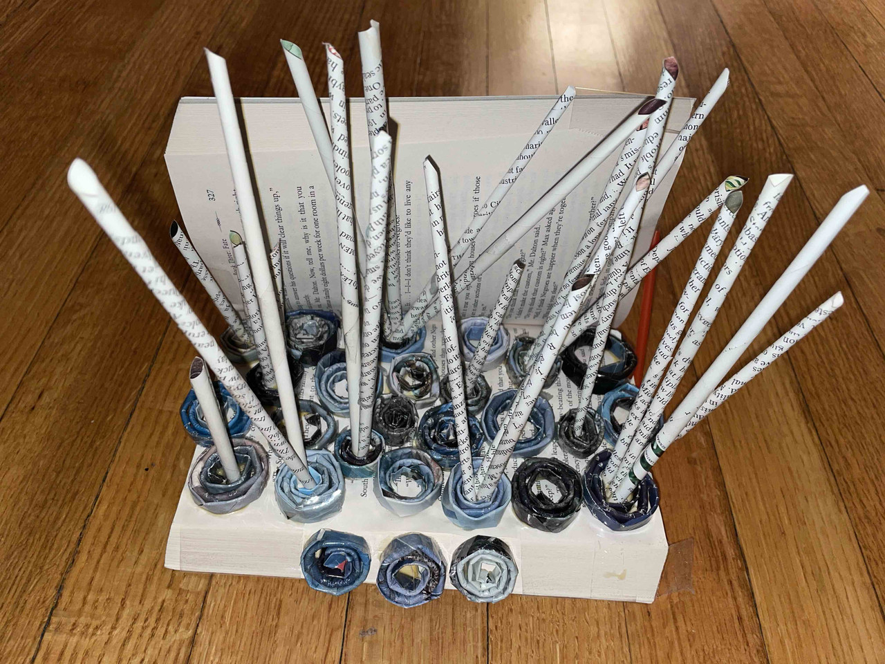 Sculpture with rings on the bottom and paper straws coming out
