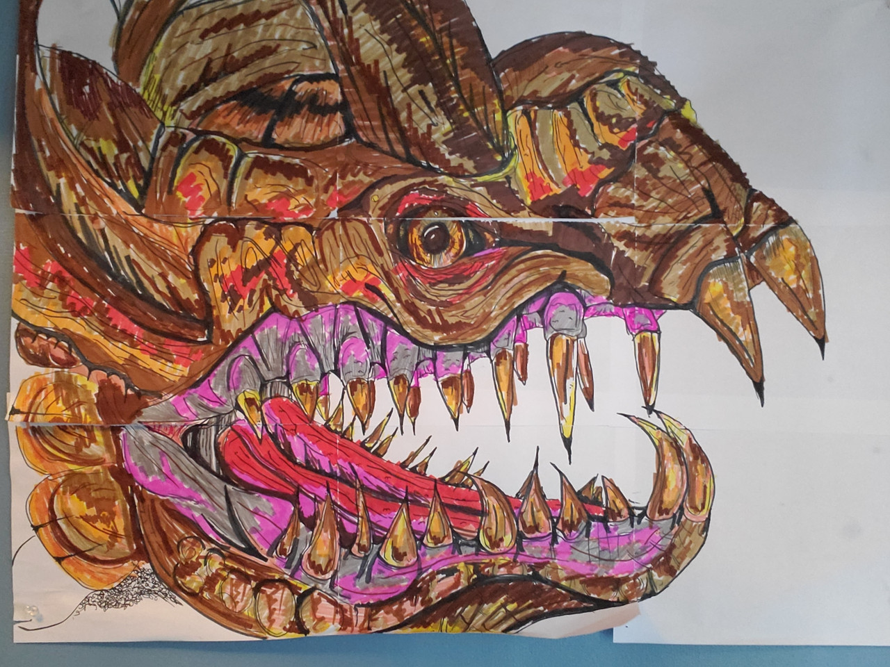 A drawing of a dragons face with large teeth