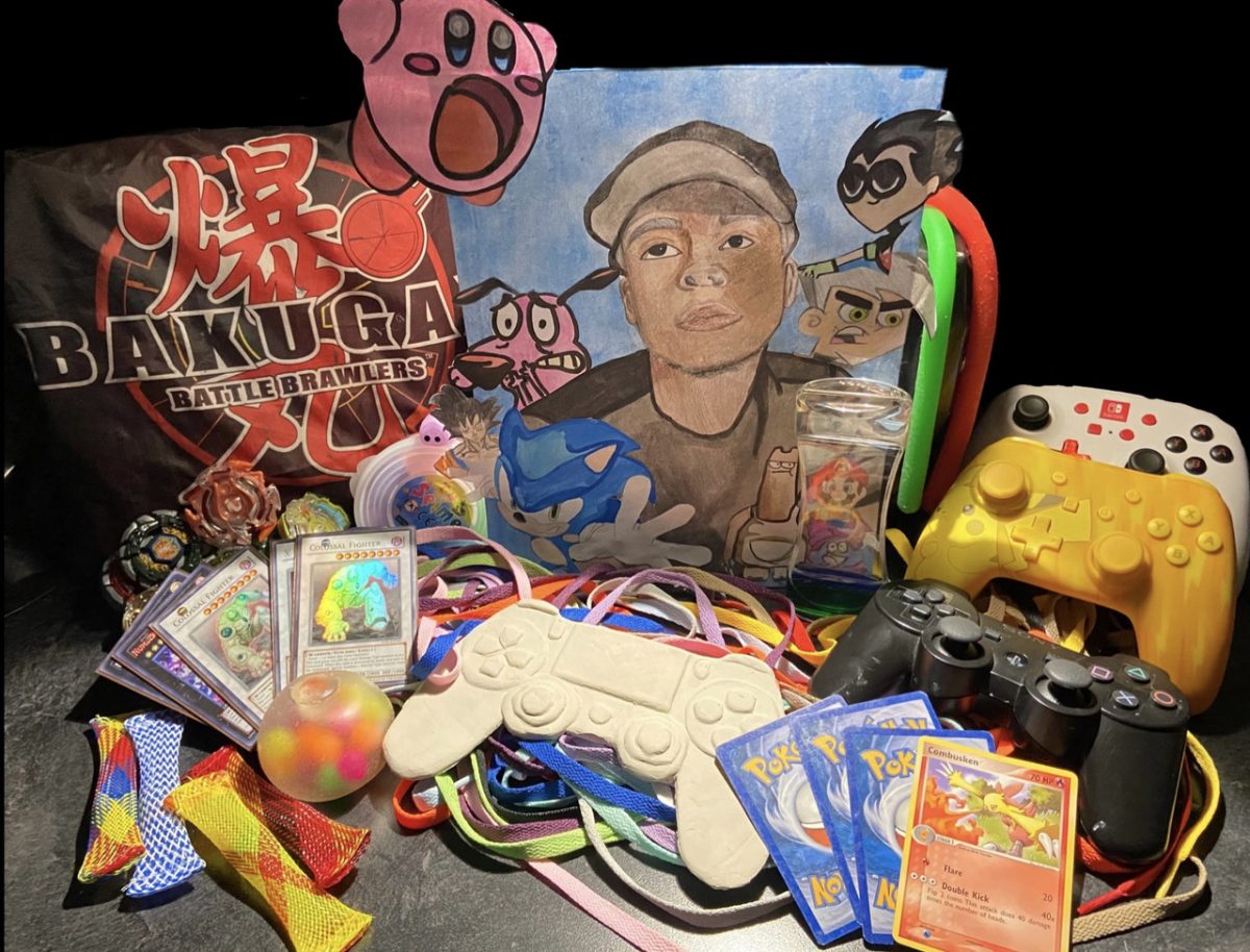 Sculpture with a drawing of a boy and kirby along with lots of other objects (game controllers, pokemon cards, etc.)