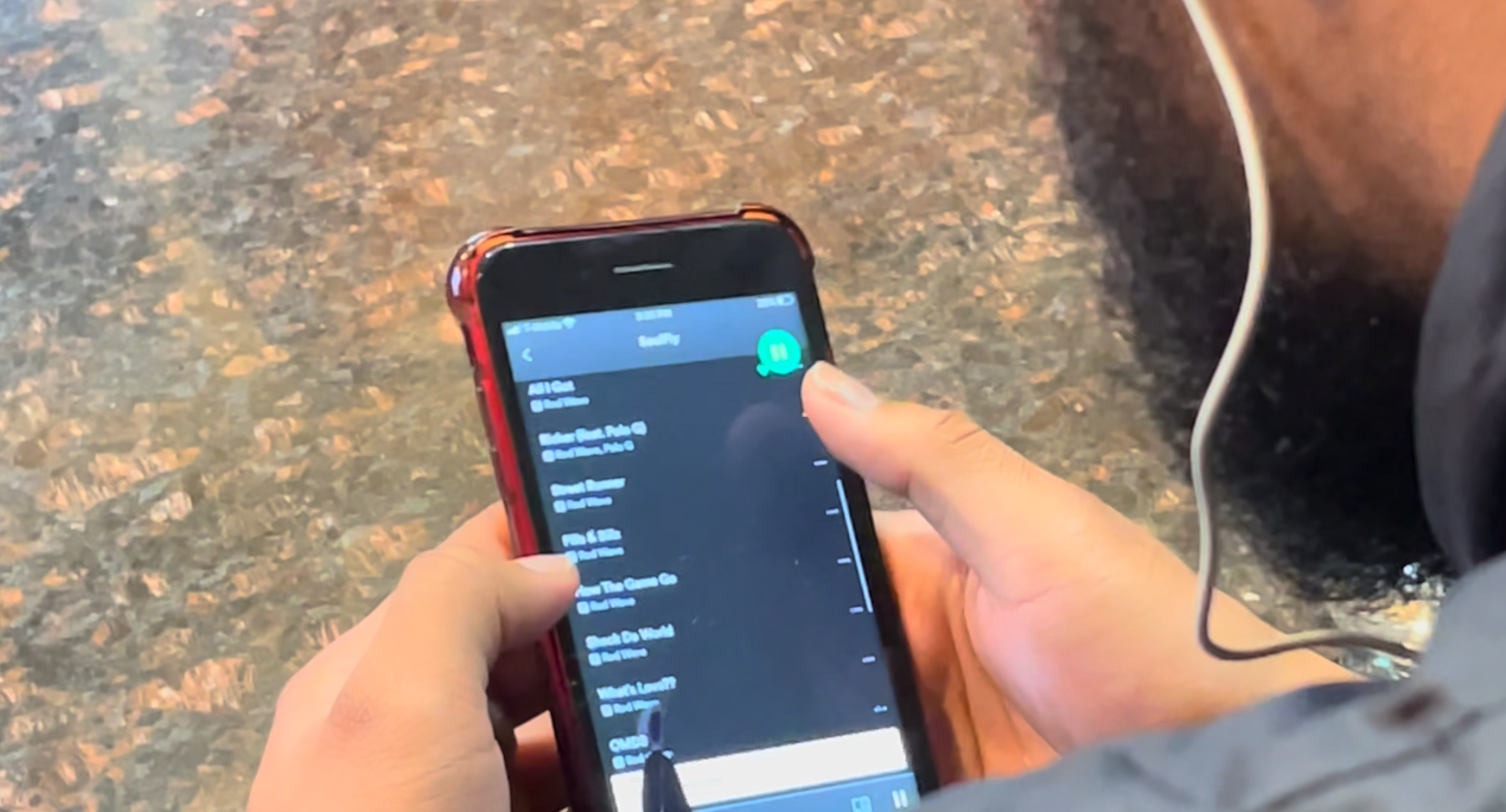 Person with beard looking at phone.