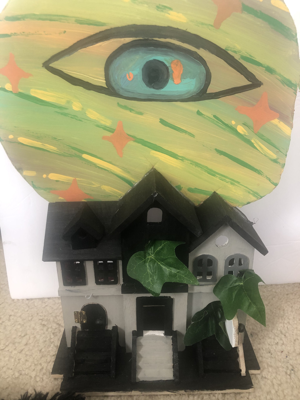 House with a big eye painting in the background