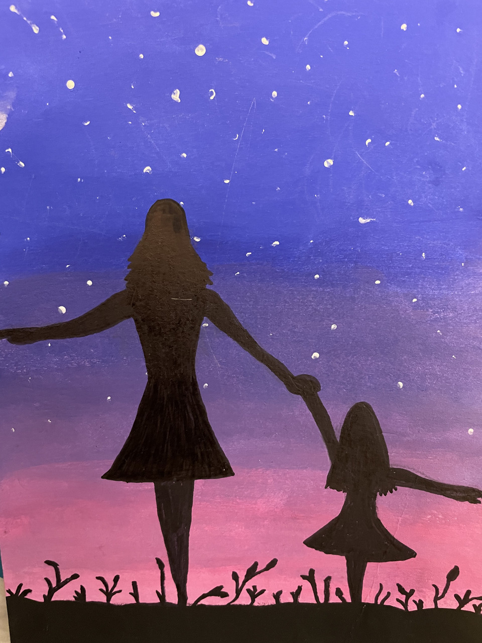 Silhouette of a mom and her daughter in front of a sunset