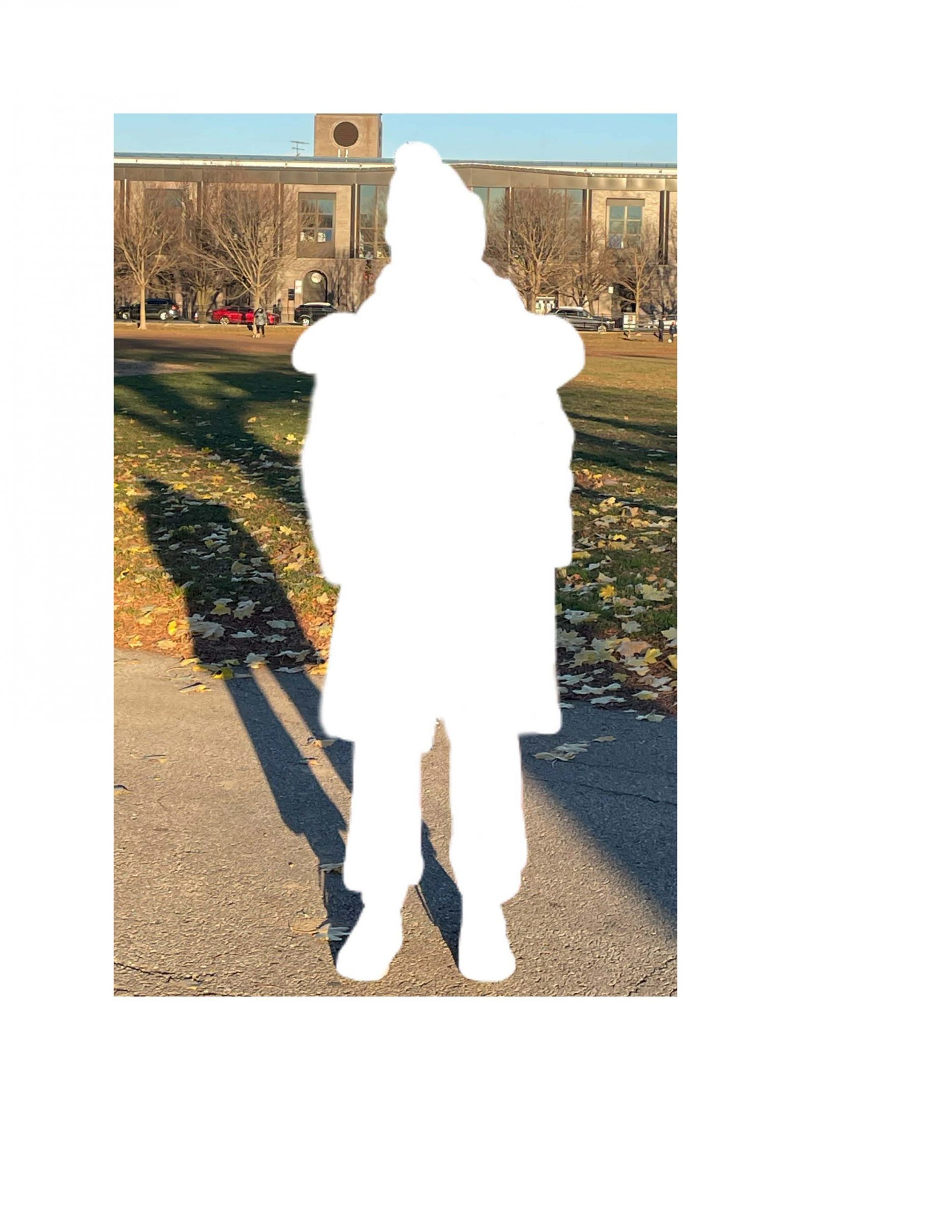 Photograph of a park with the person, wearing winter clothes, cropped out in white.