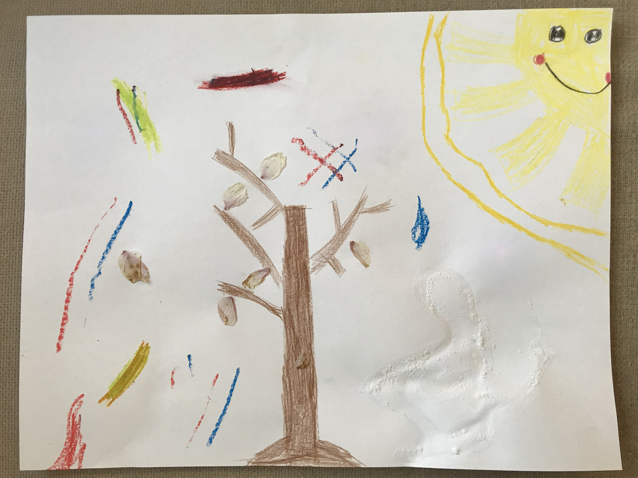 Tree with crayons, and natural materials around it.