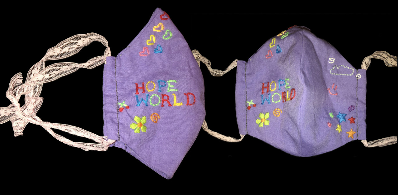 Purple fabric mask with "hope," "world," and flowers embroidered on it.