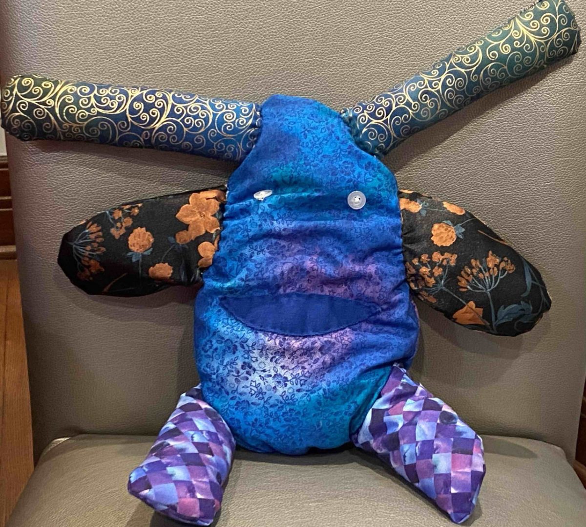 Blue, orange and purple soft sculpture of monster with horns
