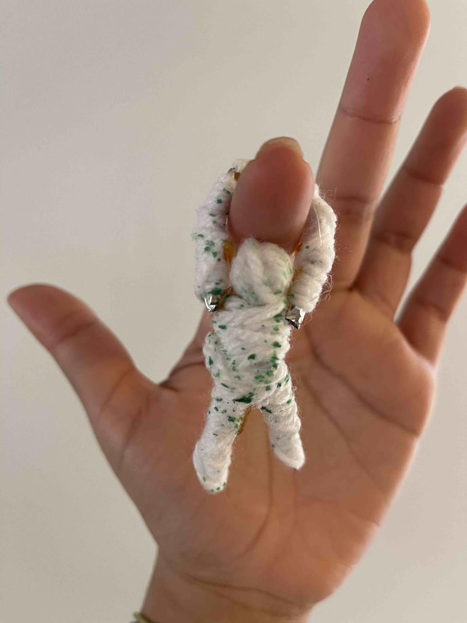 Sculpture of a person hanging from someone's hand